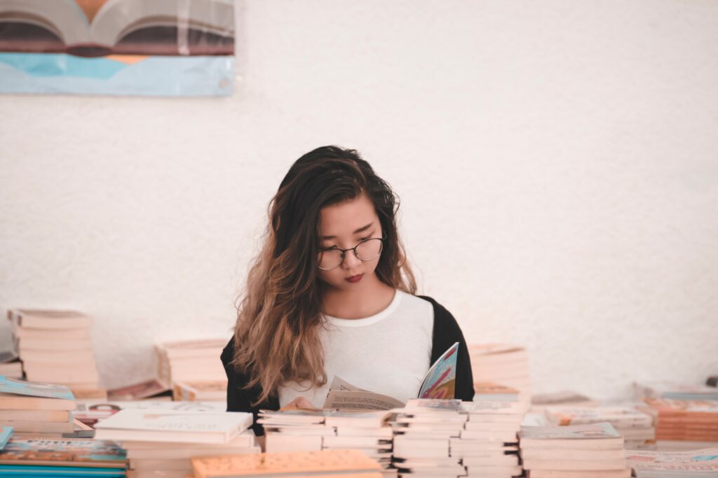 Photo of a woman reading in a room full of books